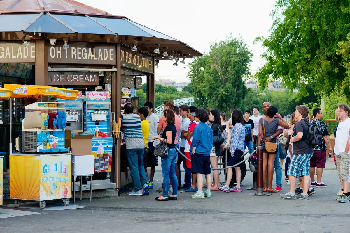 フランスパリで、暑い日の午後、公園のスタンドでアイスクリームを購入する人々の行列。
