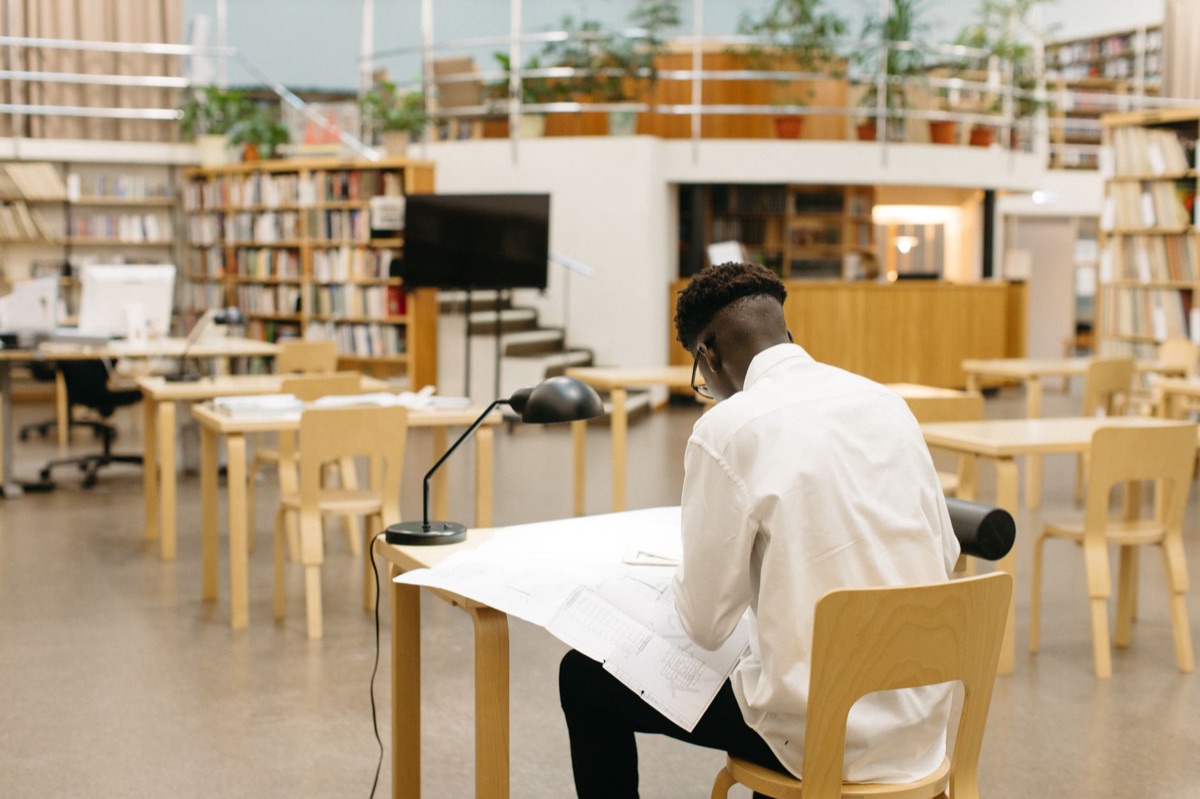 francophone elder in library reading newspaper