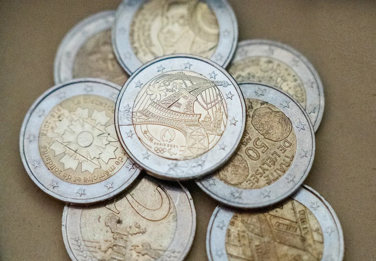 Detailed view of euro coins with a focus on the Eiffel Tower design, symbolizing Paris and France.